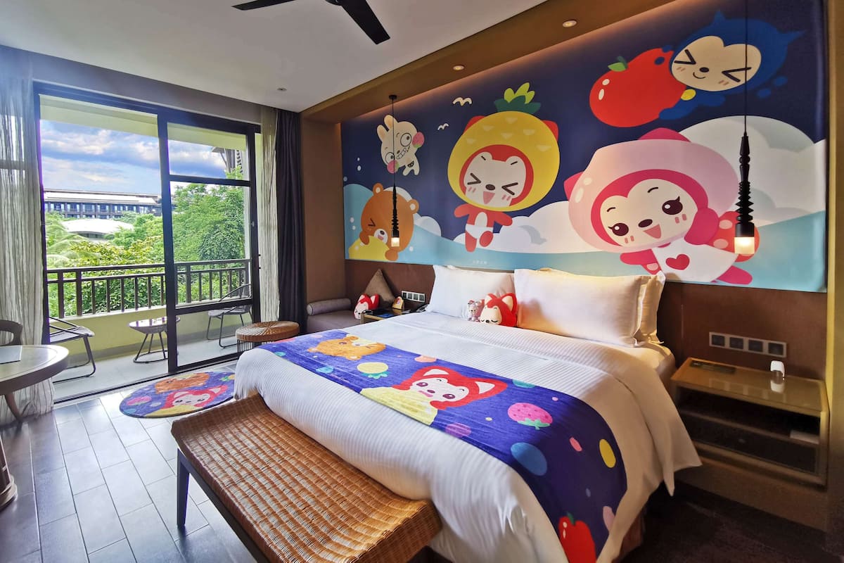 Relax in a cozy room with a large bed, balcony, and views of lush greenery.