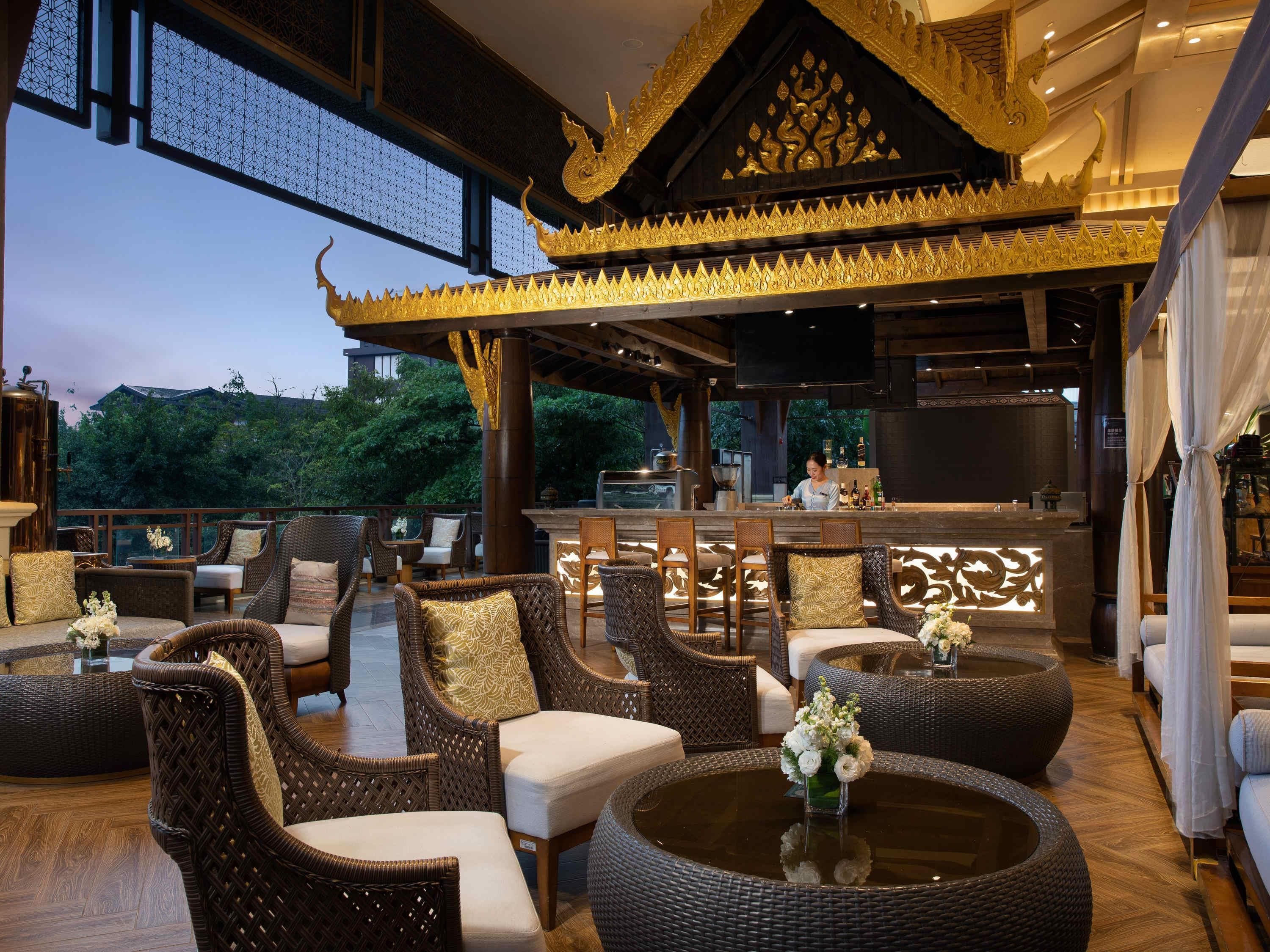 An outdoor seating area with wicker furniture and a bar.