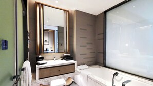 A modern bathroom with a large mirror, a vanity with a sink, a bathtub, and a shower area. - Pullman Resort Xishuangbanna (Xishuangbanna Dai)