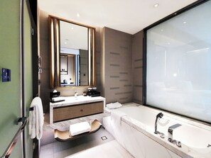 A modern bathroom with a large mirror, a vanity with a sink, a bathtub, and a shower area. - Pullman Resort Xishuangbanna (Xishuangbanna Dai)