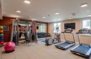 A gym with treadmills, a weight machine, dumbbells, and exercise balls. - Hampton by Hilton Frankfurt City Centre (Frankfurt)