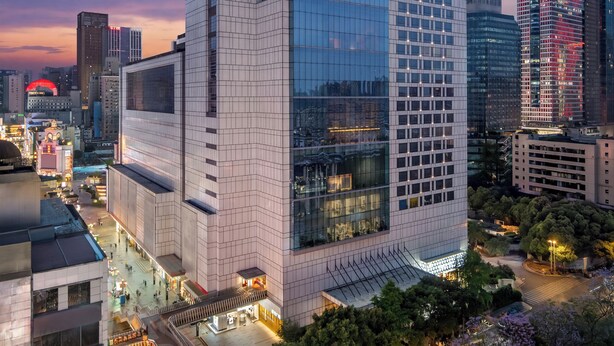 A high-rise building with a glass facade, labeled 'GRAND HYATT,' surrounded by other buildings and trees. - Grand Hyatt Chengdu (Chengdu)