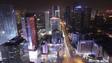 A nighttime cityscape with illuminated skyscrapers and a busy intersection.