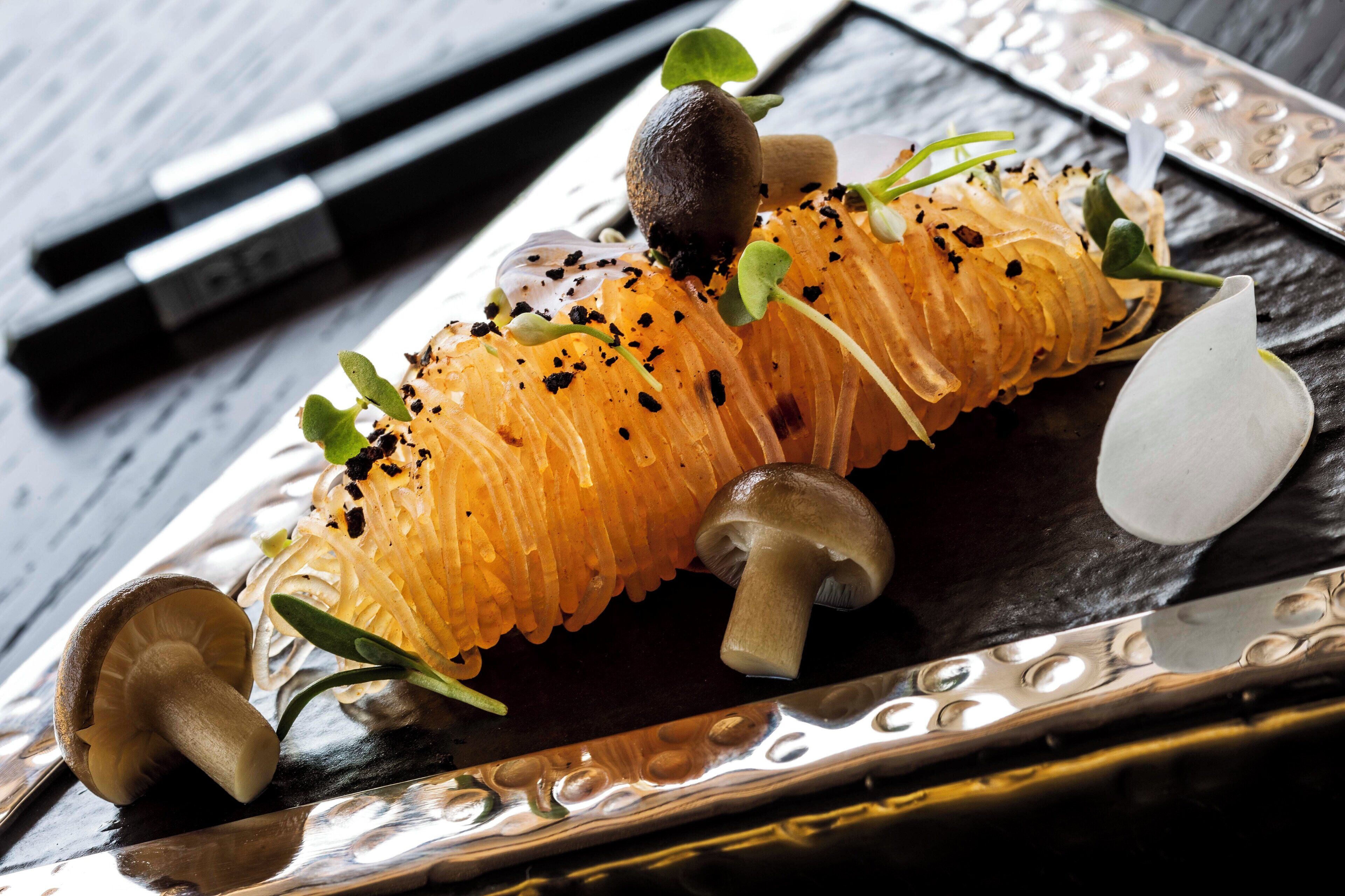 A dish with a variety of ingredients including mushrooms, herbs, and possibly some type of vegetable or fruit.