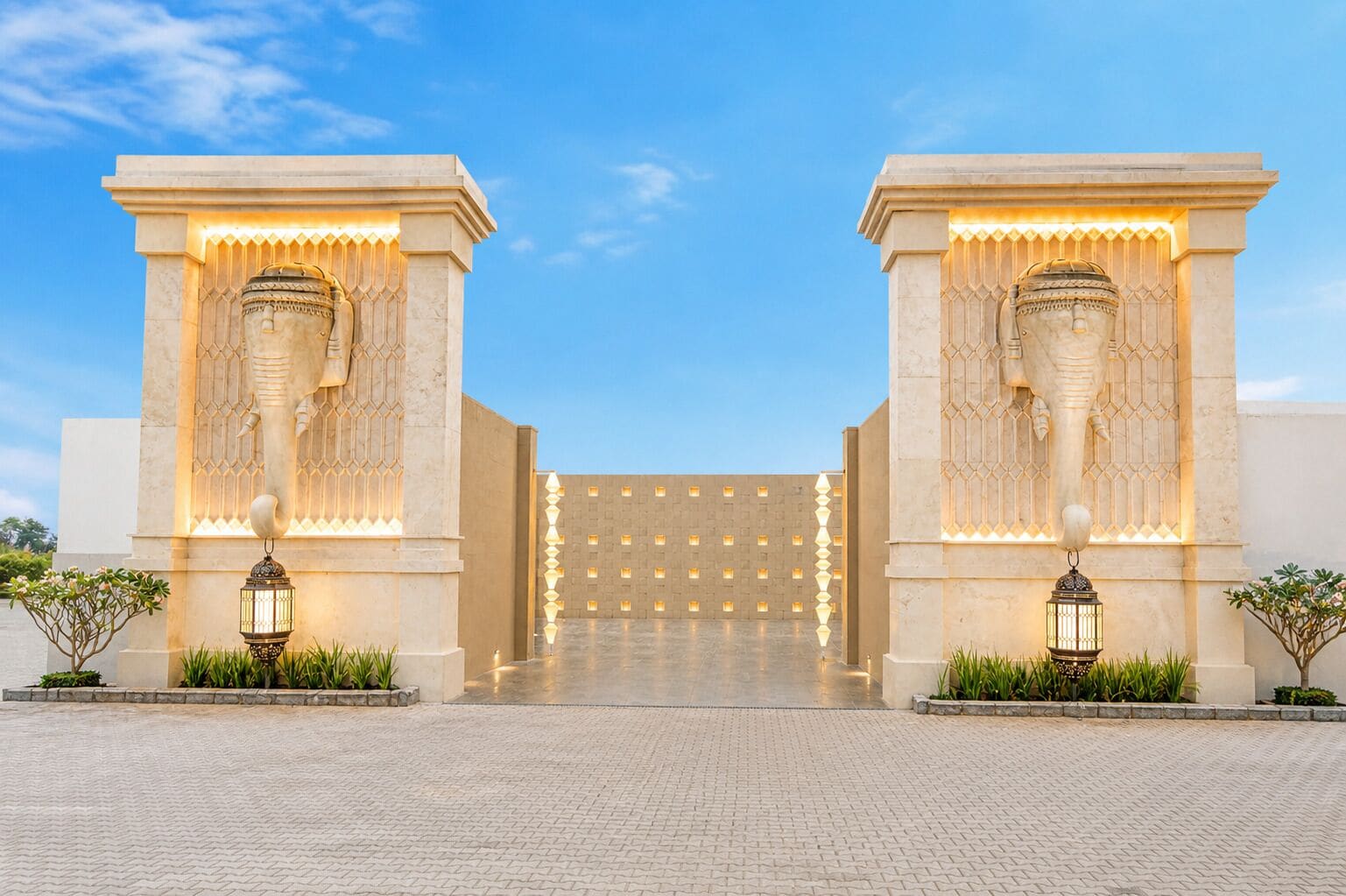 A building entrance with two large columns, a patterned wall, and a paved pathway.