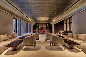 A modern lounge area with sofas, armchairs, and a bar. - InterContinental Chennai Mahabalipuram Resort by IHG (Tirupporur)