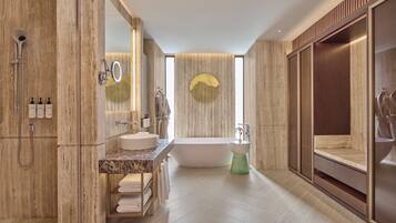 A modern bathroom with a freestanding bathtub, a vanity with a marble countertop, and a large mirror.