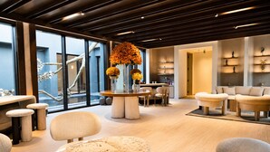 A modern interior with a round table, chairs, and a sofa area.