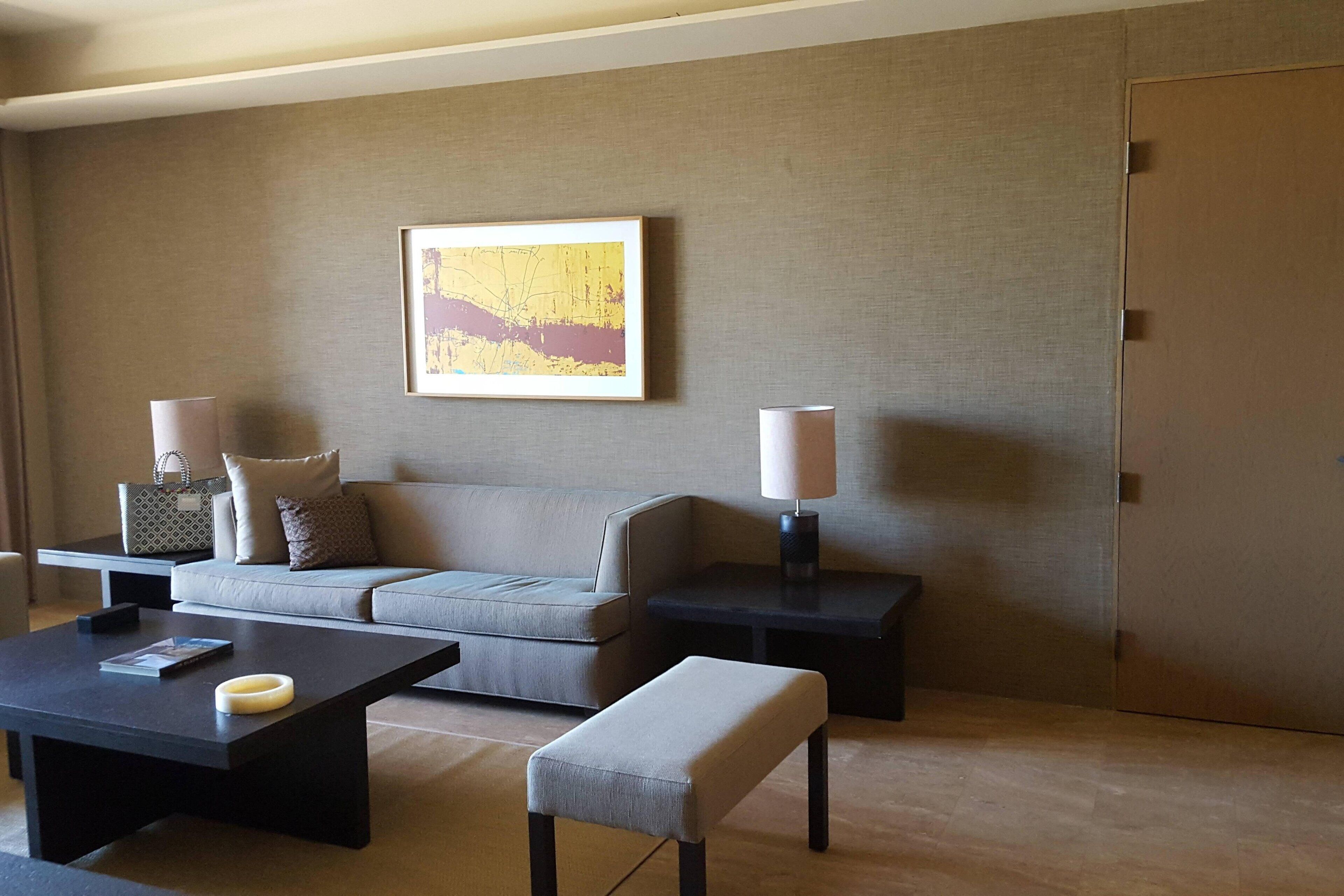 A modern living room with a sofa, a coffee table, a side table, and a lamp.