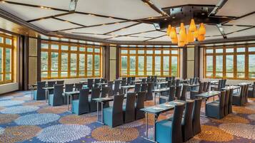 A conference room with a patterned carpet, modern chairs, and large windows offering a view of the outdoors.