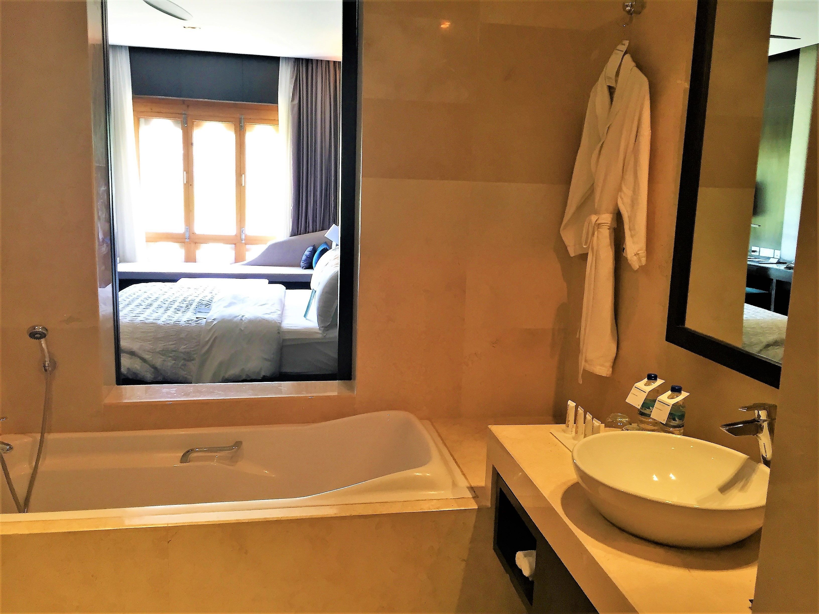 A modern bathroom with a bathtub, a large sink, and a mirror.