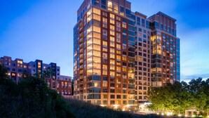 A multi-story hotel with a modern architectural design, featuring balconies and large windows.
