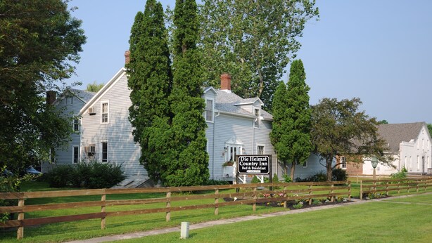 A traditional country inn with a sign indicating it offers bed and breakfast services. - Die Heimat Country Inn (Homestead)