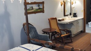 A bedroom with a bed, a chair, a desk, and a hanging white lace canopy. - Die Heimat Country Inn (Homestead)