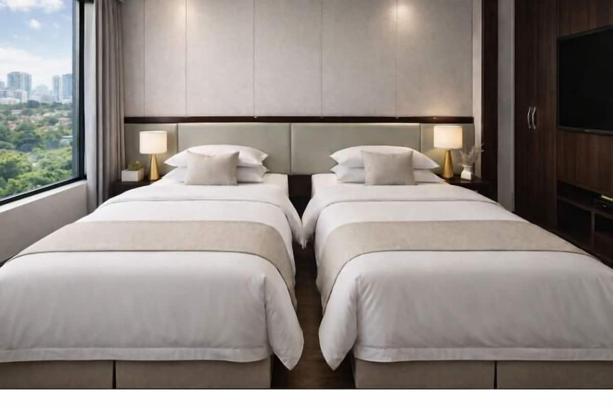 Ein Hotelzimmer mit zwei Betten, Blick auf die Stadt und einem Flachbildfernseher.
