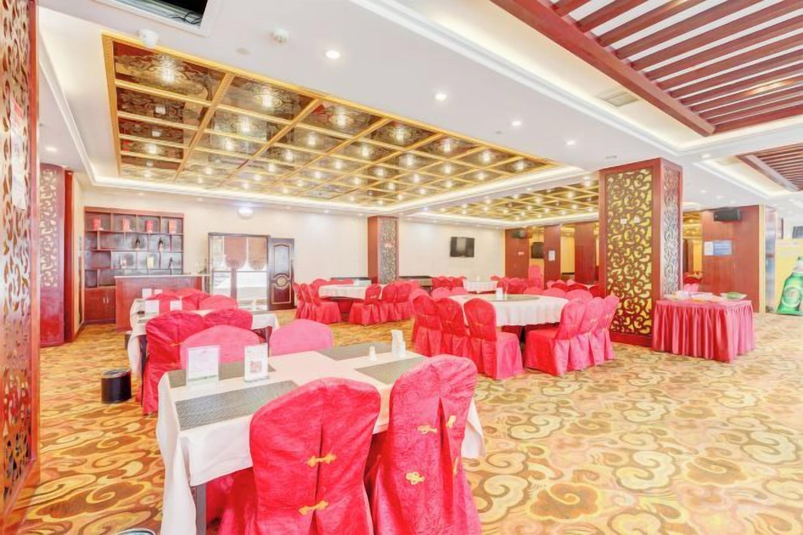 A banquet hall with tables set for events, a patterned carpet, and a decorative ceiling.