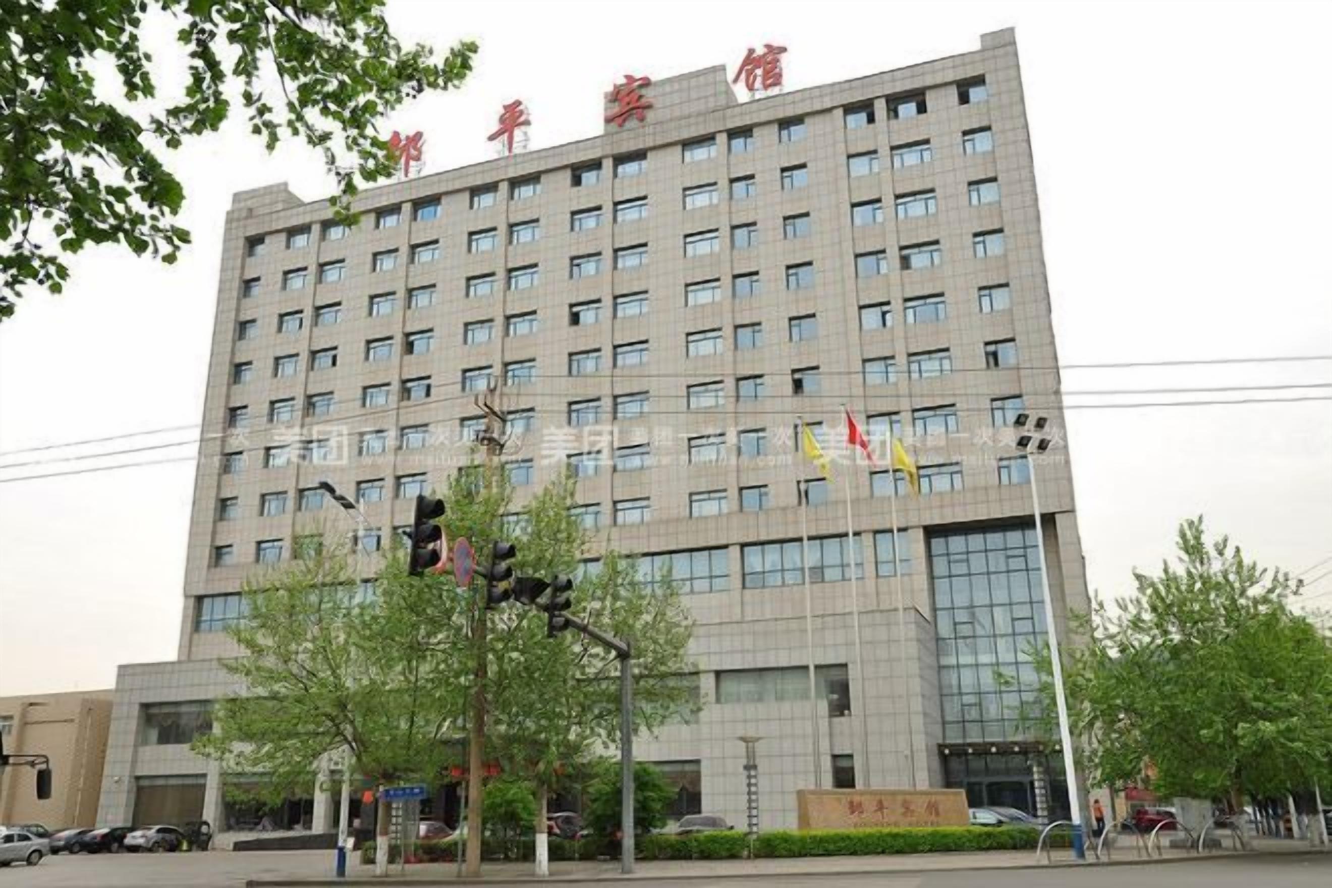 A multi-story building with a large number of windows and a sign with Chinese characters.