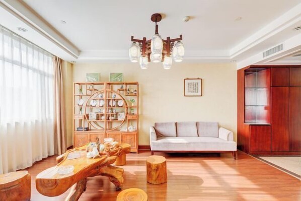 Un salón amplio con una mesa de centro de madera, un sofá y un aparador de madera.