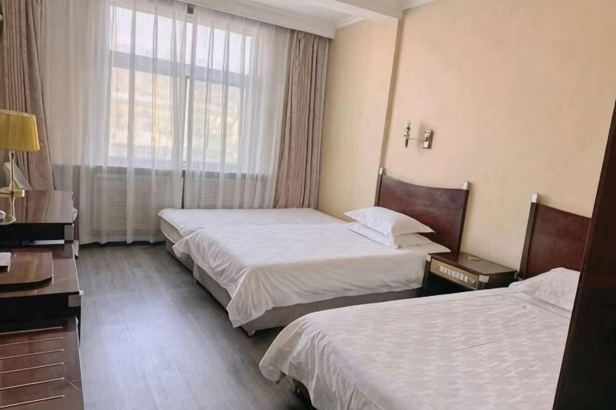 Una habitación de hotel con dos camas, un escritorio y una silla.