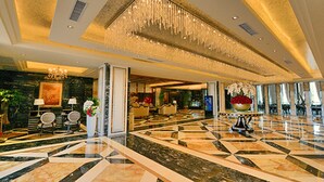 A spacious lobby with a geometric marble floor, a grand chandelier, and a reception area with seating. - Country Garden Sun City Phoenix Hotel (Shaoguan)