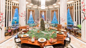 A luxurious hotel lobby with a central dining area, large chandeliers, and elegant decor. - Country Garden Sun City Phoenix Hotel (Shaoguan)
