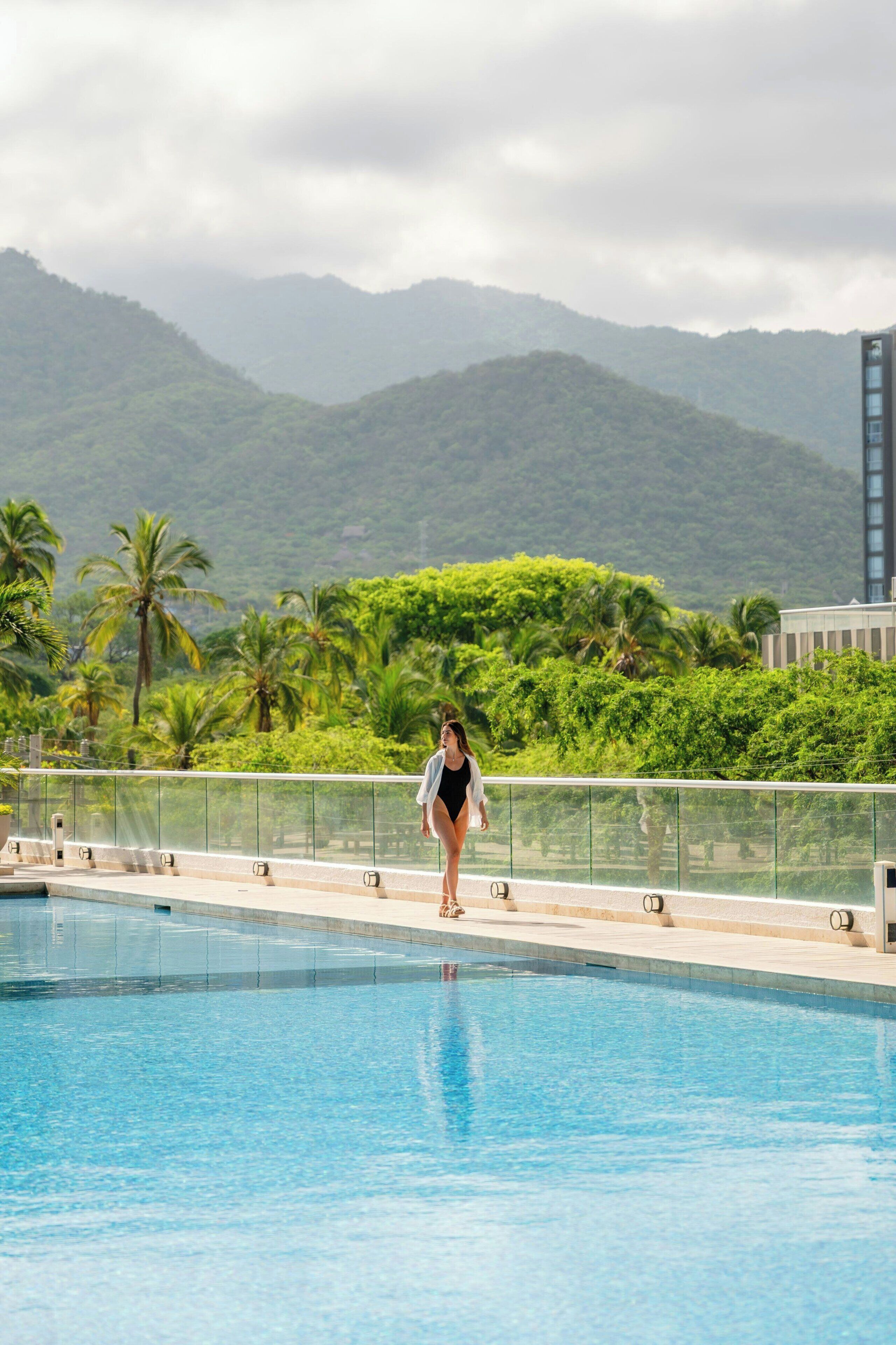 Una piscina con vistas a un paisaje montañoso y palmeras.