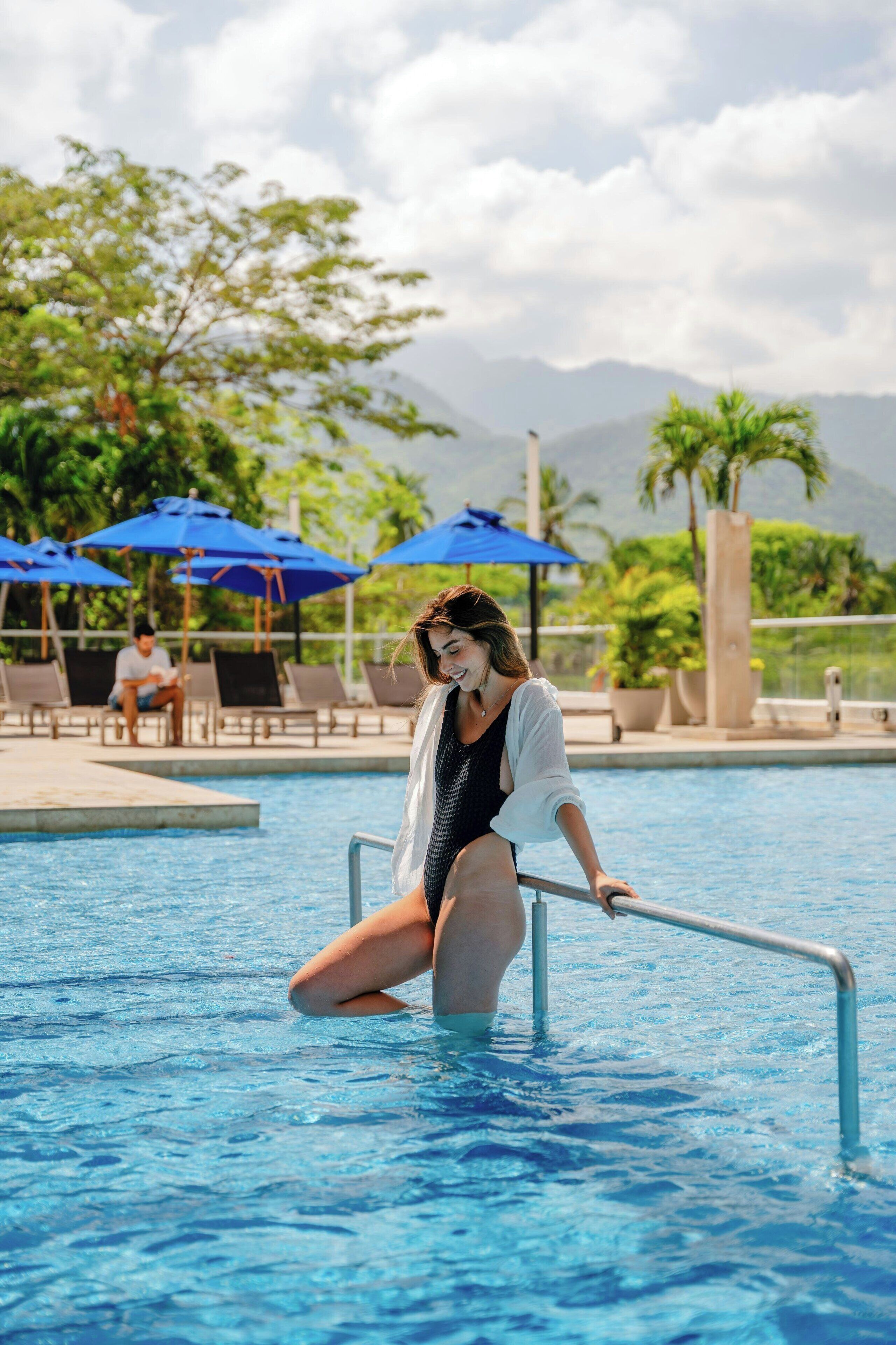 Une personne assise sur le bord d’une piscine.