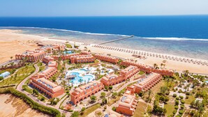 An aerial view of a resort with a large pool, beach, and ocean. - Novotel Marsa Alam Beach Resort (El Quseir)
