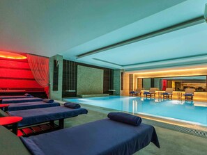 Una piscina cubierta, tumbonas
