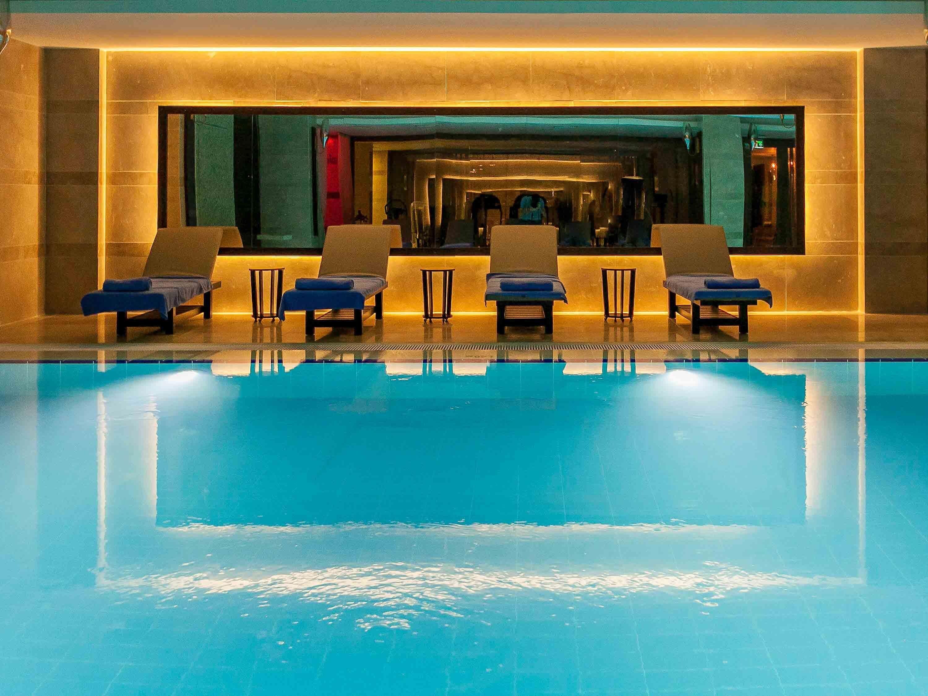 A swimming pool with lounge chairs and a spa area.
