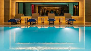 A swimming pool with lounge chairs and a spa area.