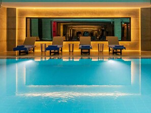 Una piscina con sillas de descanso y un área de spa.