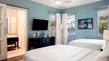 A bedroom with two beds, a TV, and a painting.