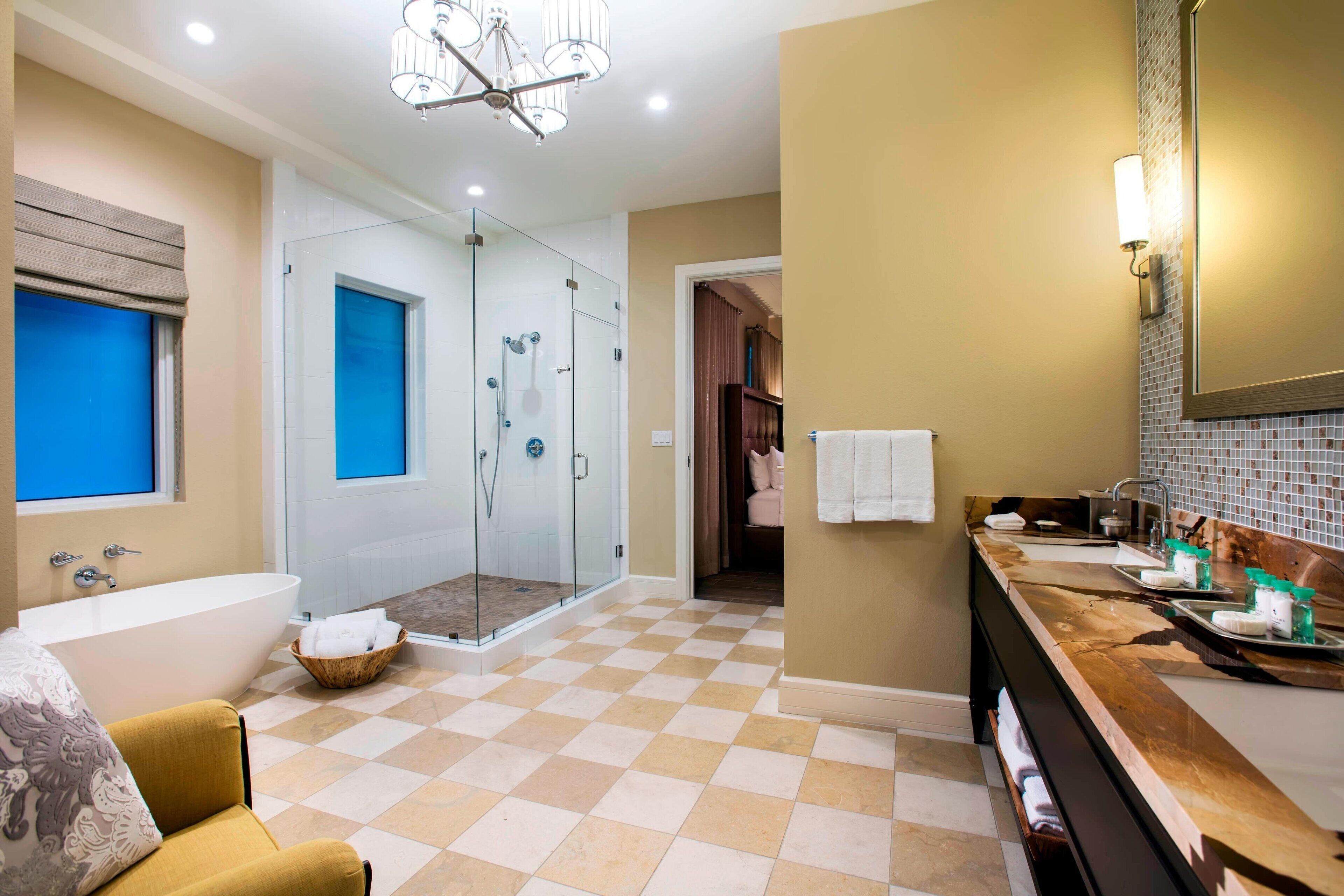 A modern bathroom with a glass-enclosed shower, a bathtub, and a vanity with a sink and mirror.