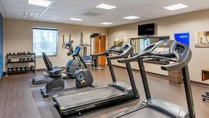 Un gimnasio con cintas de correr, elípticas y pesas sueltas.