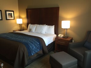 A hotel room with a large bed, two bedside tables with lamps, a chair, and a small table. - Comfort Inn & Suites Lynchburg Airport - University Area (Lynchburg)