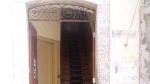 A staircase leading to a room with a tiled floor and a door on the left.