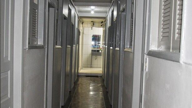 A narrow hallway with doors on both sides leading to individual rooms.