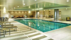 An indoor swimming pool with lounge chairs and a seating area. - Doubletree By Hilton Reading (Reading)