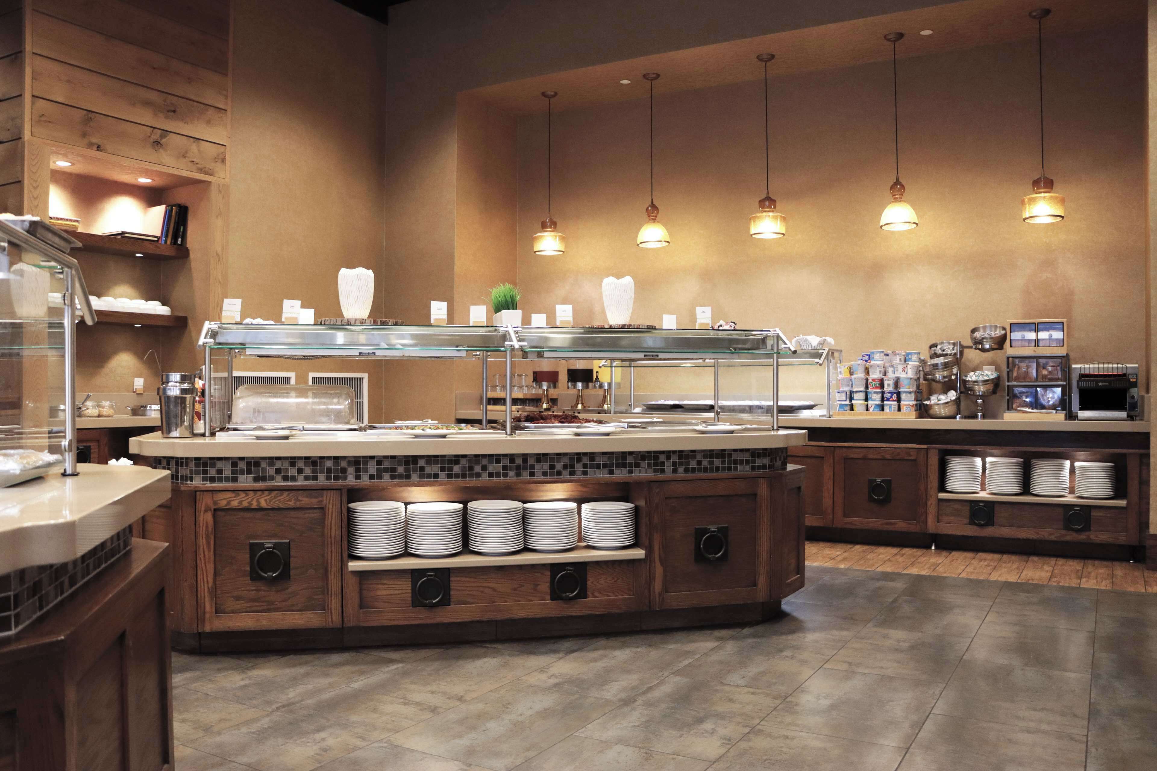 A buffet area with a central serving station, multiple food display cases, and a variety of food items.