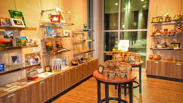 Ein gut beleuchteter Laden mit Holzböden, der Bücher, Keramik und Dekorationsobjekte präsentiert.