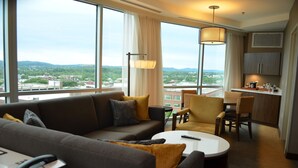 A hotel room with a sofa, armchair, and dining area. - Doubletree By Hilton Reading (Reading)