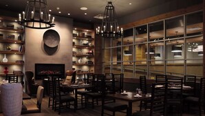 A restaurant with a cozy interior, featuring wooden walls, a fireplace, and a large window. - Doubletree By Hilton Reading (Reading)