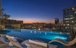 Una piscina al aire libre, sillones reclinables de piscina
