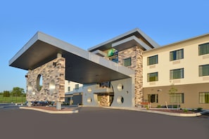 Un hôtel moderne doté d’une architecture originale, caractérisée par de grandes fenêtres circulaires et une corniche saillante.