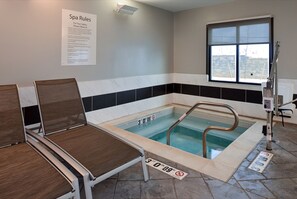 A spa area with a hot tub, seating, and a window.
