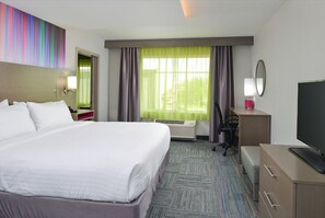 A hotel room with a large bed, a desk with a computer, a television, and a window with curtains. - Holiday Inn Express & Suites Shippensburg by IHG (Shippensburg)