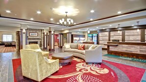 A spacious lobby with a red carpet, a fireplace, a reception desk, and a seating area with sofas and chairs. - Homewood Suites by Hilton Bridgewater/Branchburg (Branchburg)