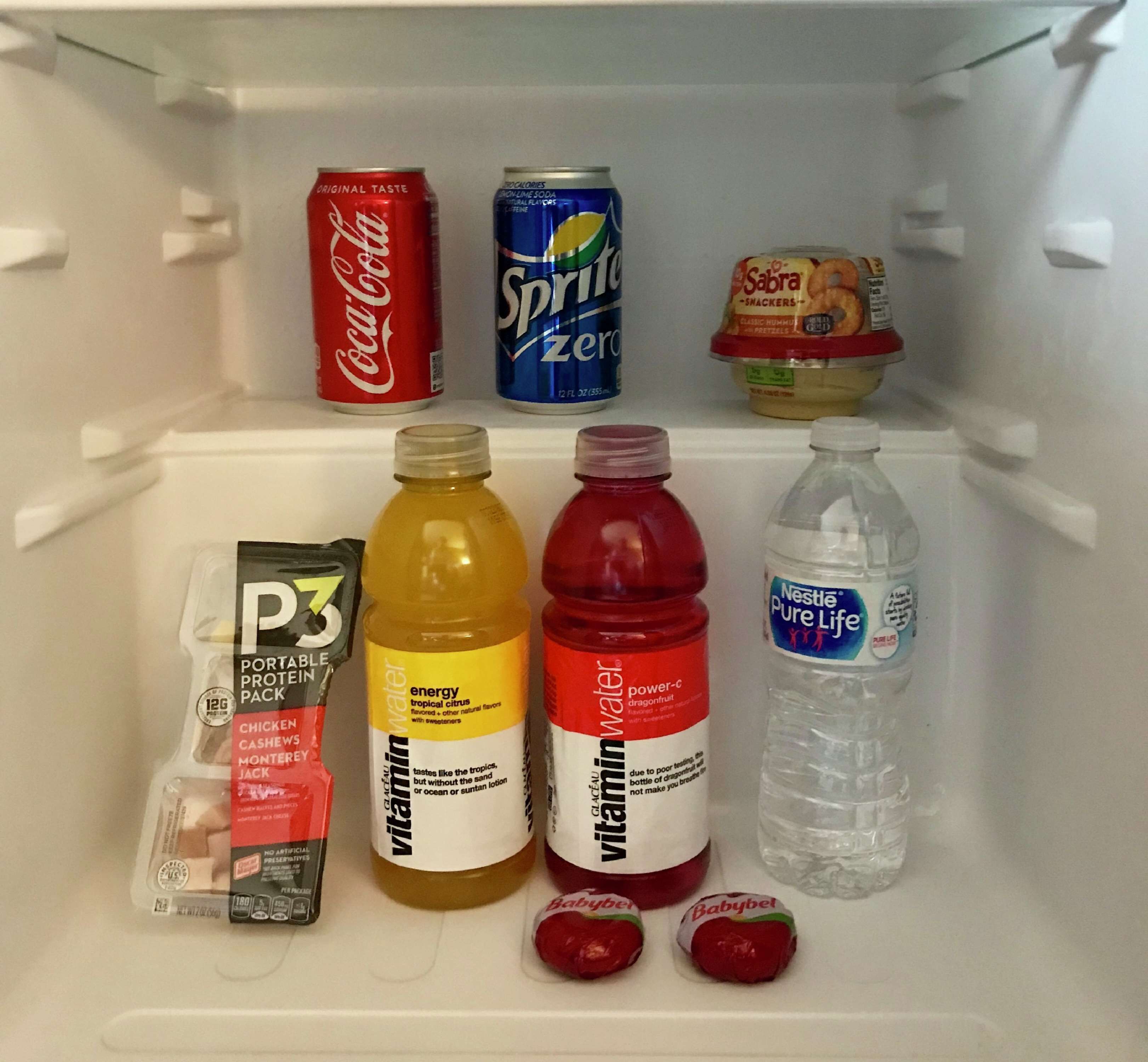A refrigerator containing various beverages and snacks.