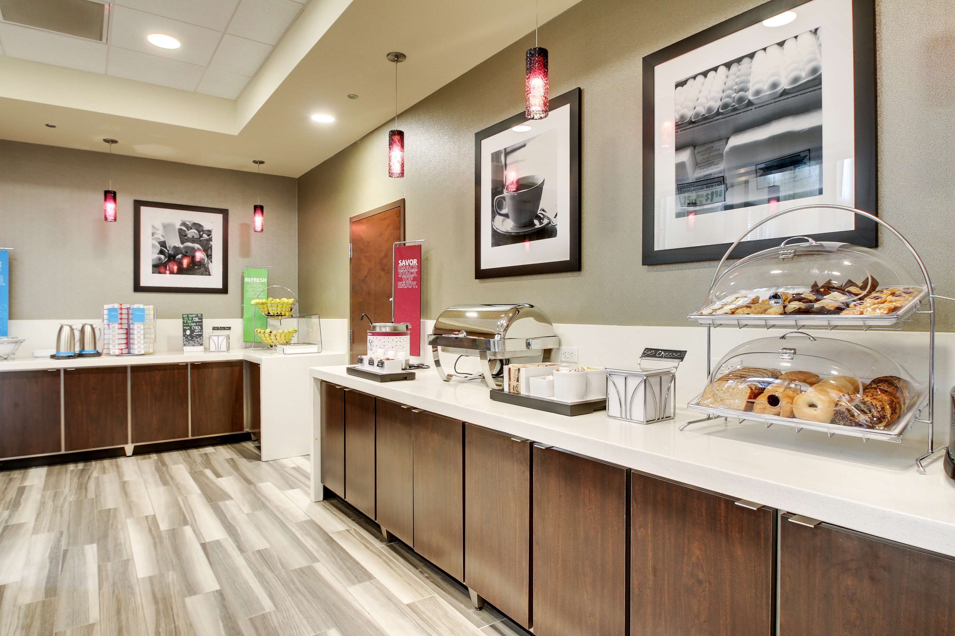 A hotel reception area with a counter displaying pastries and a coffee station.